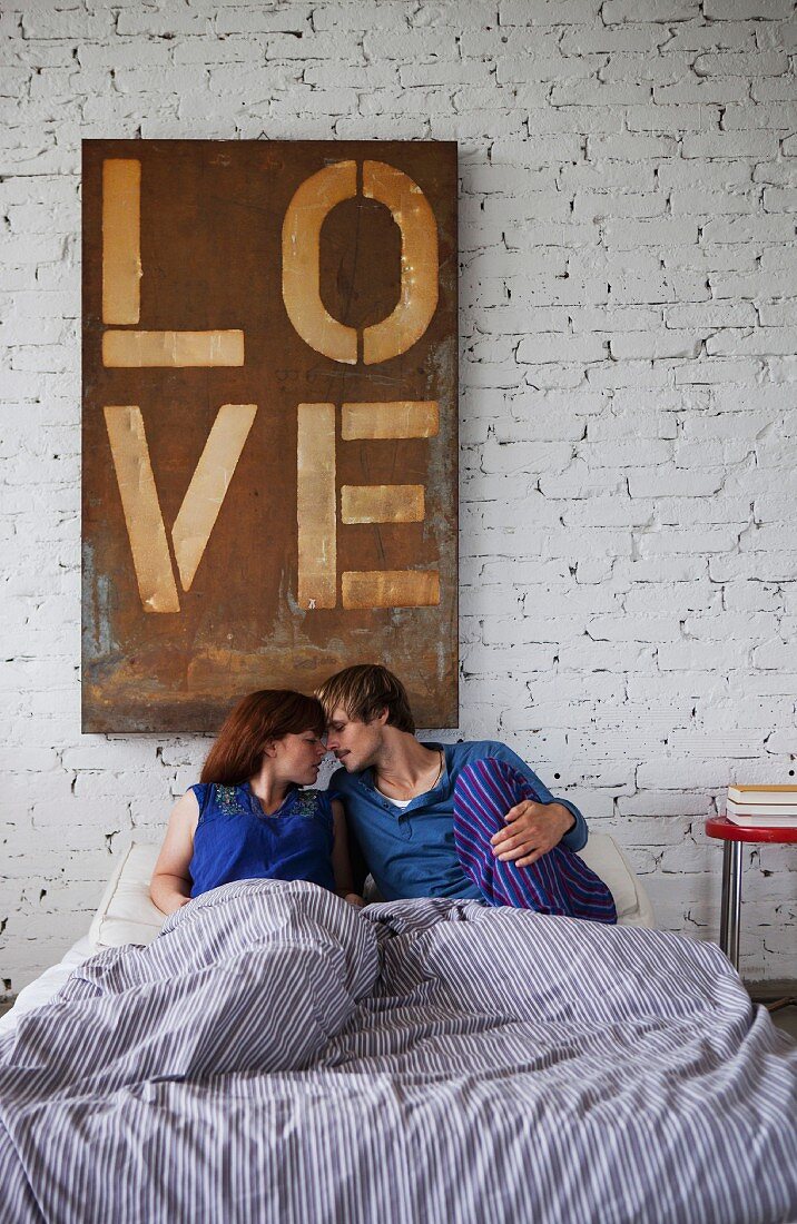 Verliebtes junges Paar im Bett liegend
