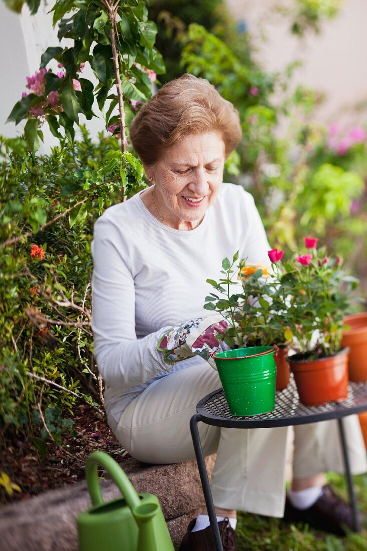 Eine ältere Frau mit Topfblumen