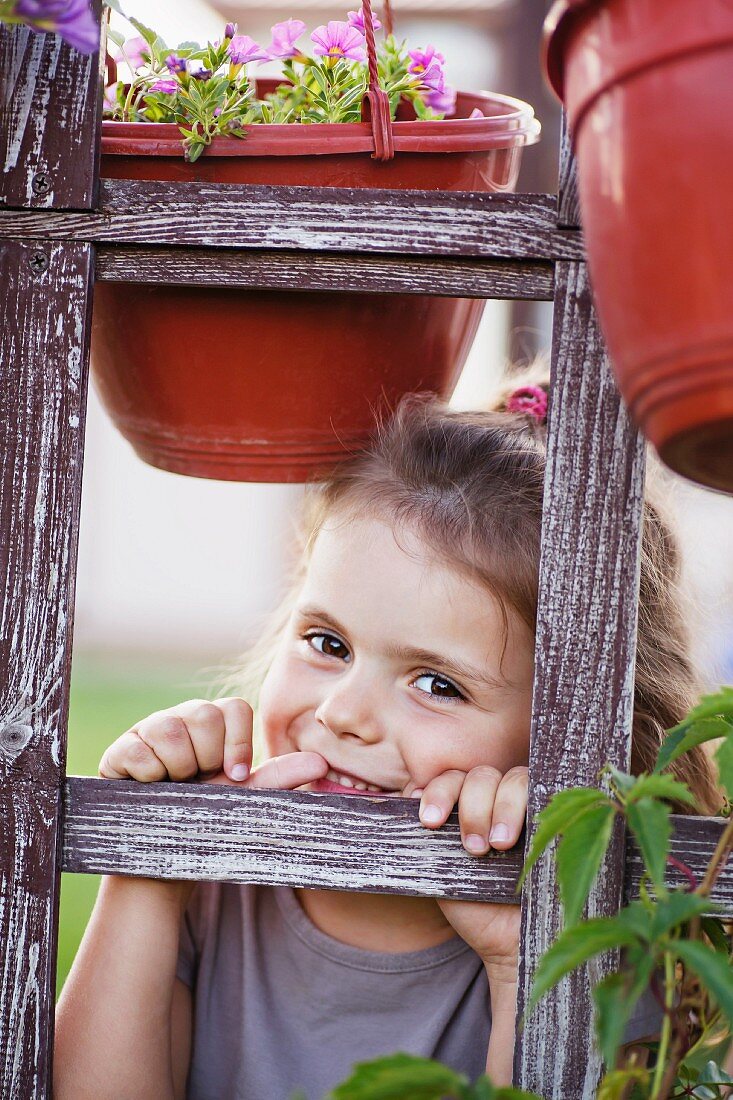 Lächelndes kleines Mädchen hinter einem Spalier