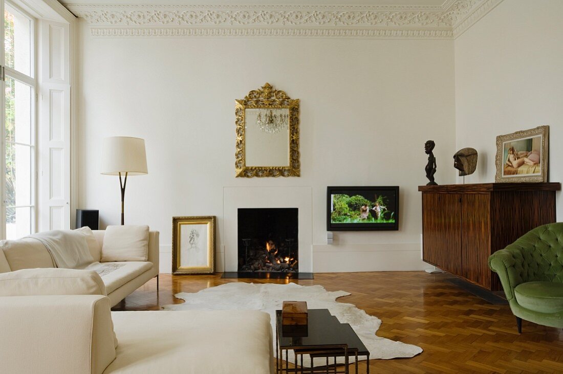 Elegantes helles Wohnzimmer mit Stuckleiste und brennendem Kaminfeuer in einem viktorianischen Stadthaus