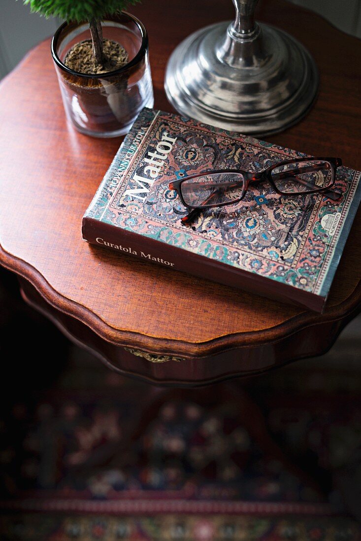 Reading glasses and book on delicate side table