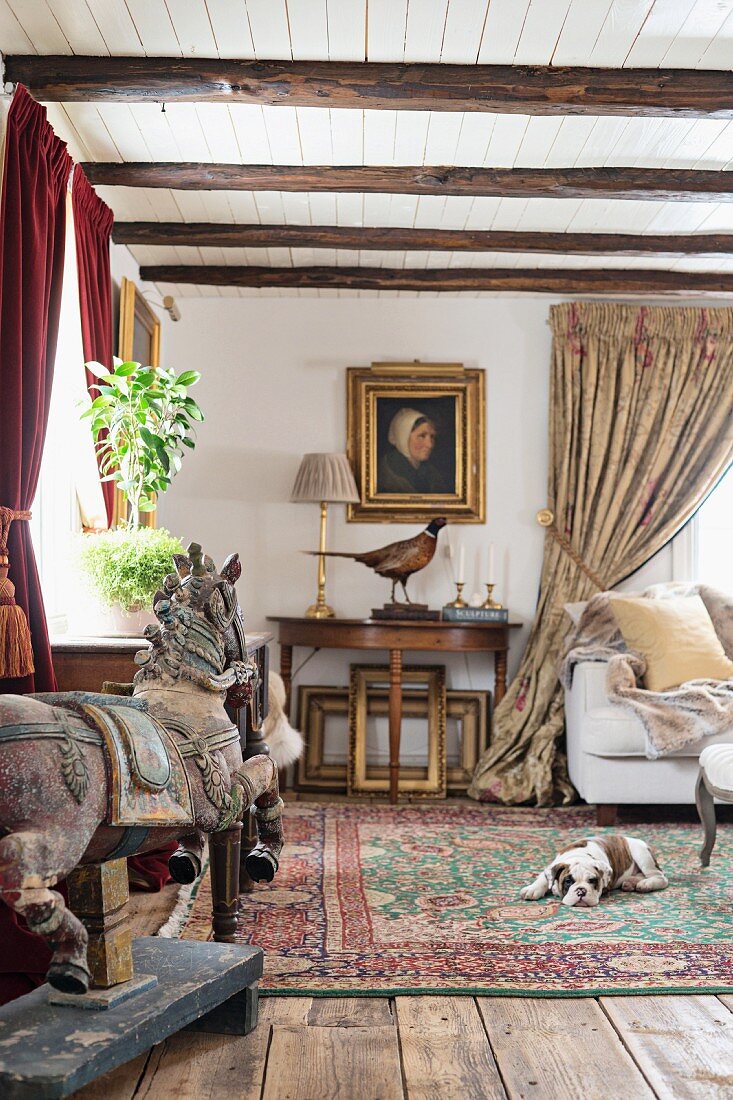 Salon mit antiken Stilmöbeln, geschnitztes Pferd auf Stellage, Hund auf Orientteppich