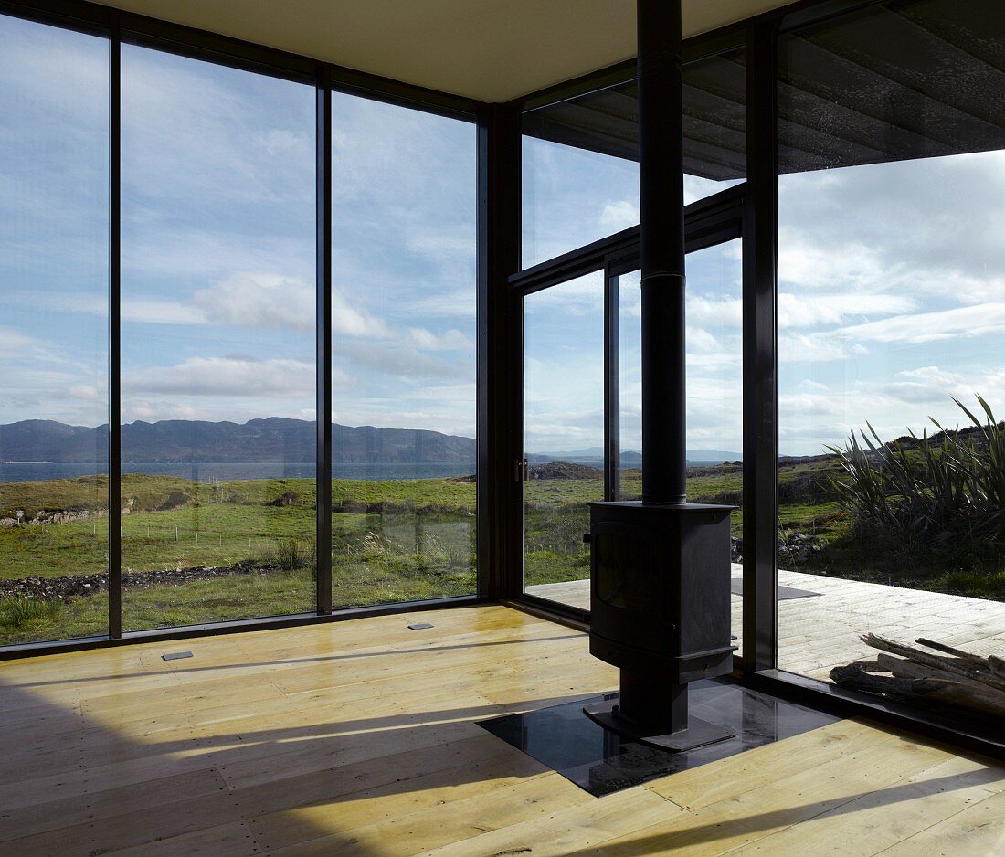 Moderner leerer Wohnraum mit freistehendem Kaminofen und Panoramablick