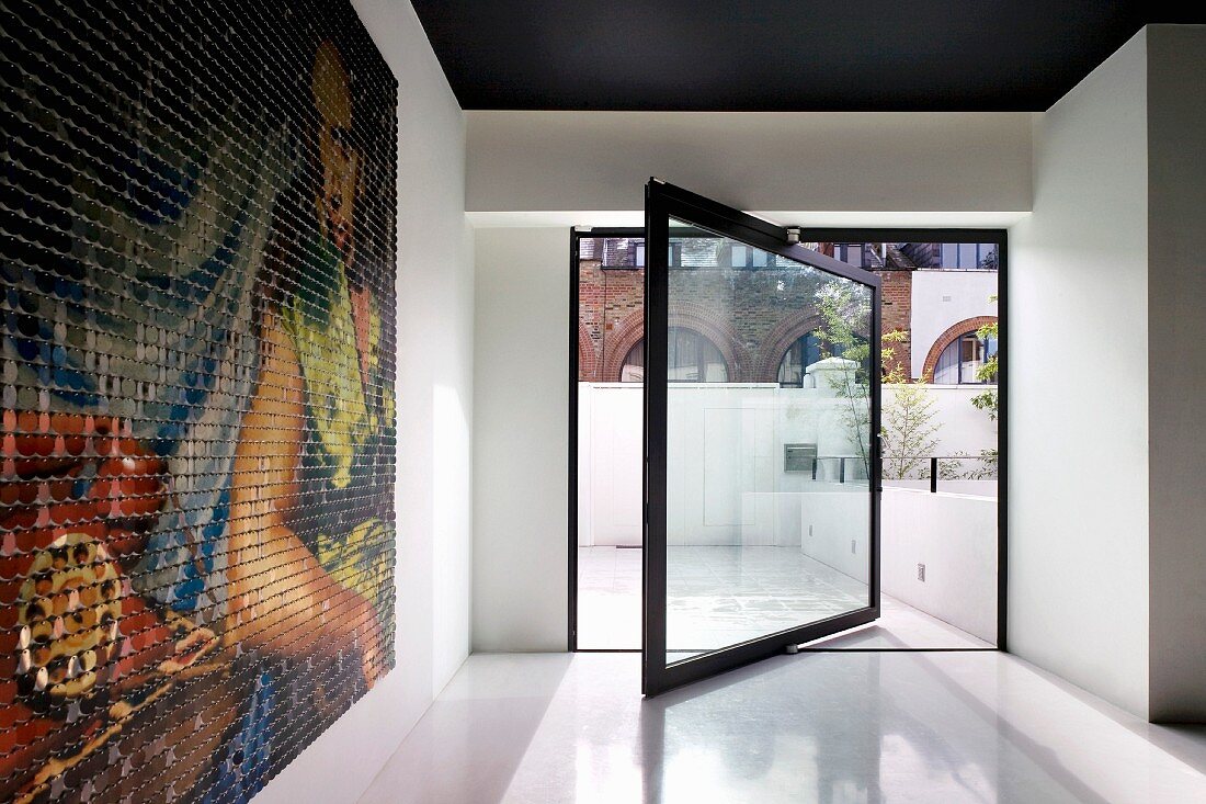Minimalistischen Raum mit drehbarer raumhoher Fensterscheibe und modernem Bild