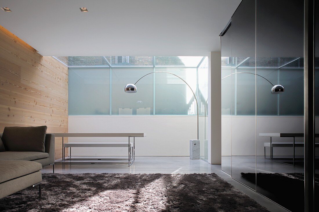 Designer Wohn- und Essraum mit Bogenlampe aus Bauhauszeit über Essplatz im verglasten Erker
