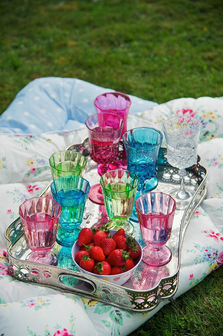 Silbertablett mit bunten Gläsern und Erdbeeren