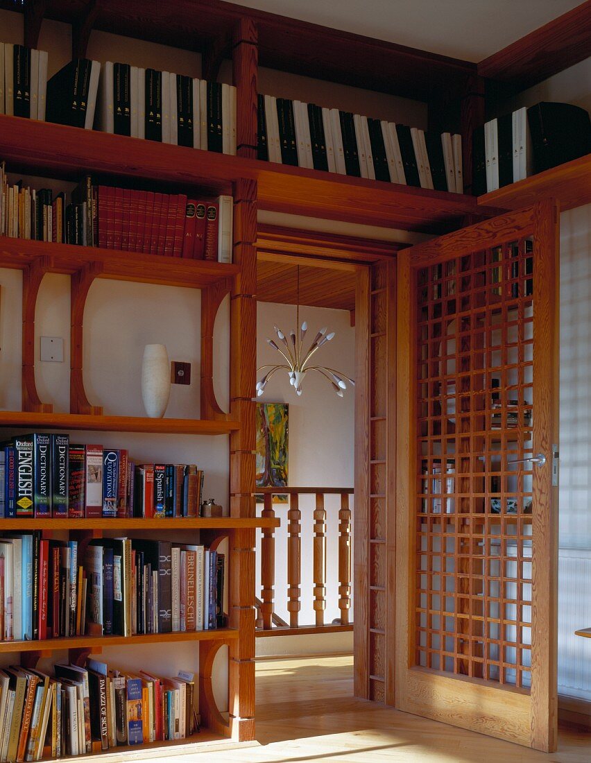 Bibliothek im asiatischen Stil mit offener Tür und Holzgitterfüllung mit Blick auf Treppenhaus