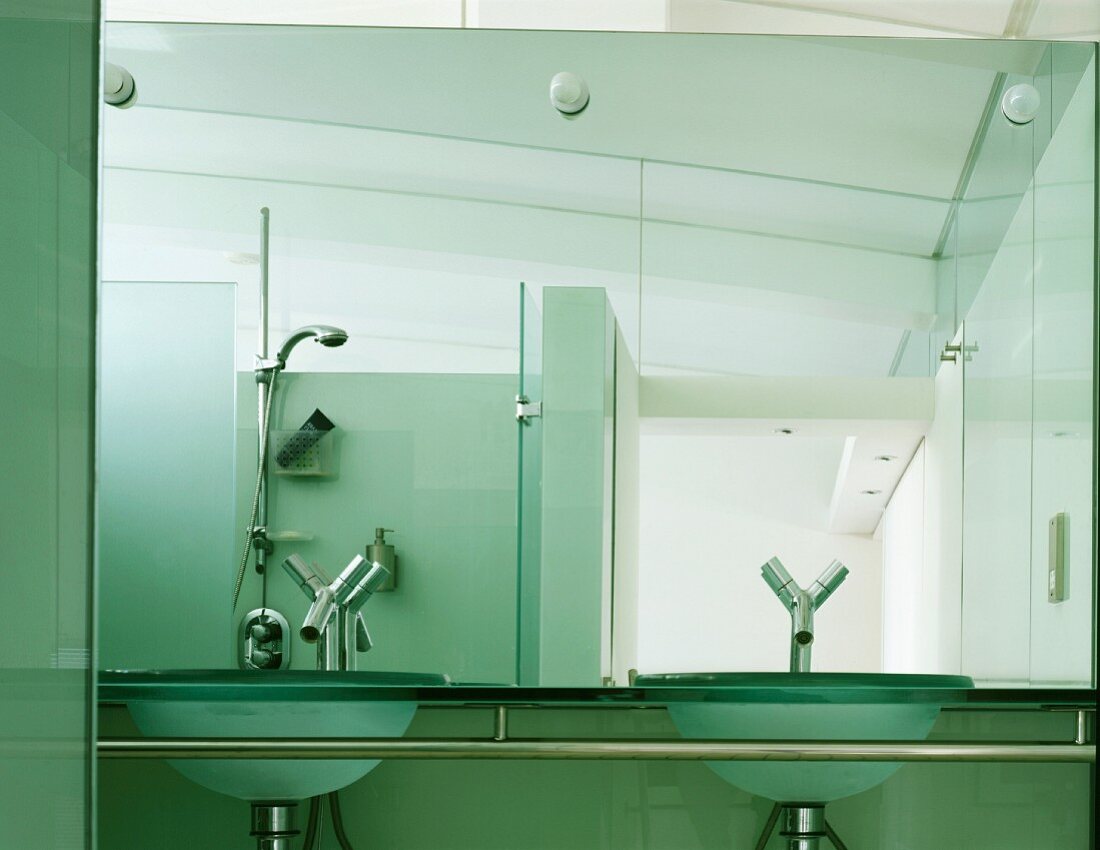 Designerbad mit Waschschüsseln aus Glas und Designerarmaturen vor Wandspiegel