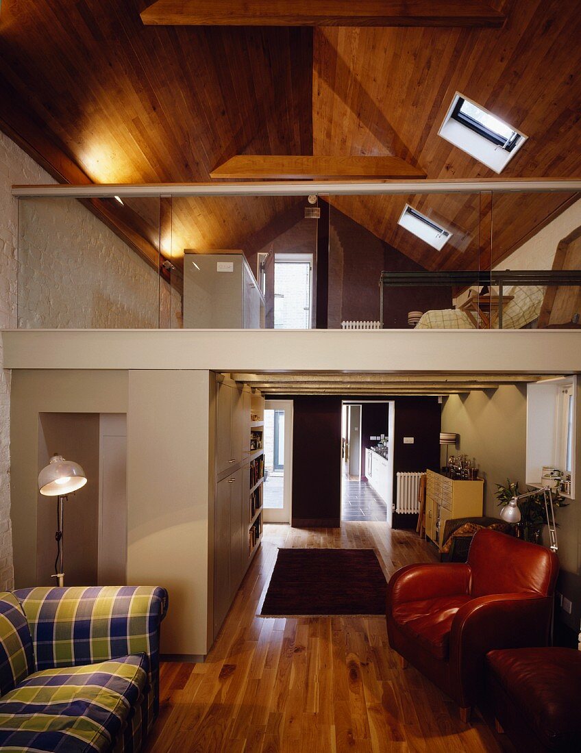 Wohnraum im ausgebauten Dach mit Galerie und Holzverkleidung an Decke
