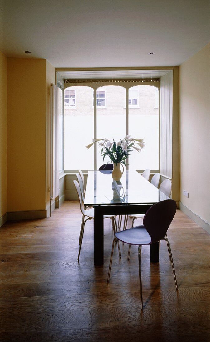 Esstisch mit Glasplatte und Retro Schalenstühle vor Fenster im Jugendstil