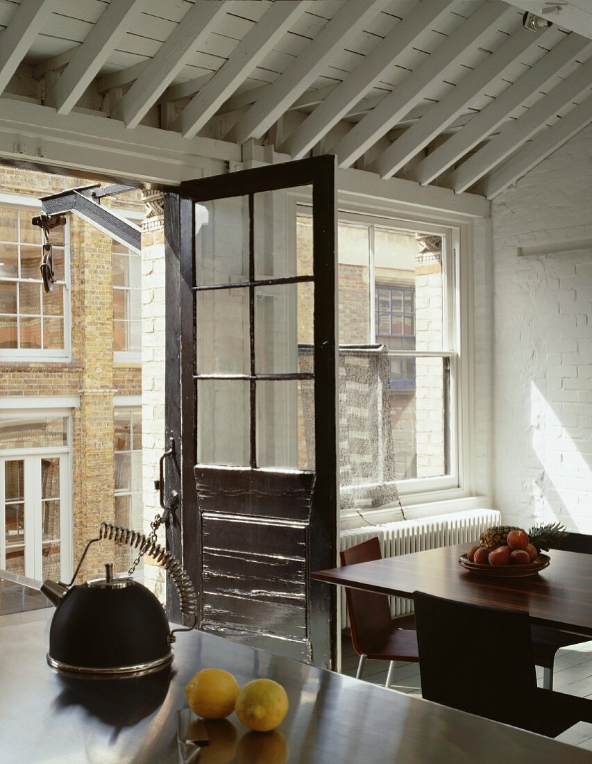 Offene Balkontür im Vintagestil in designter Küche mit weisser Holzdecke