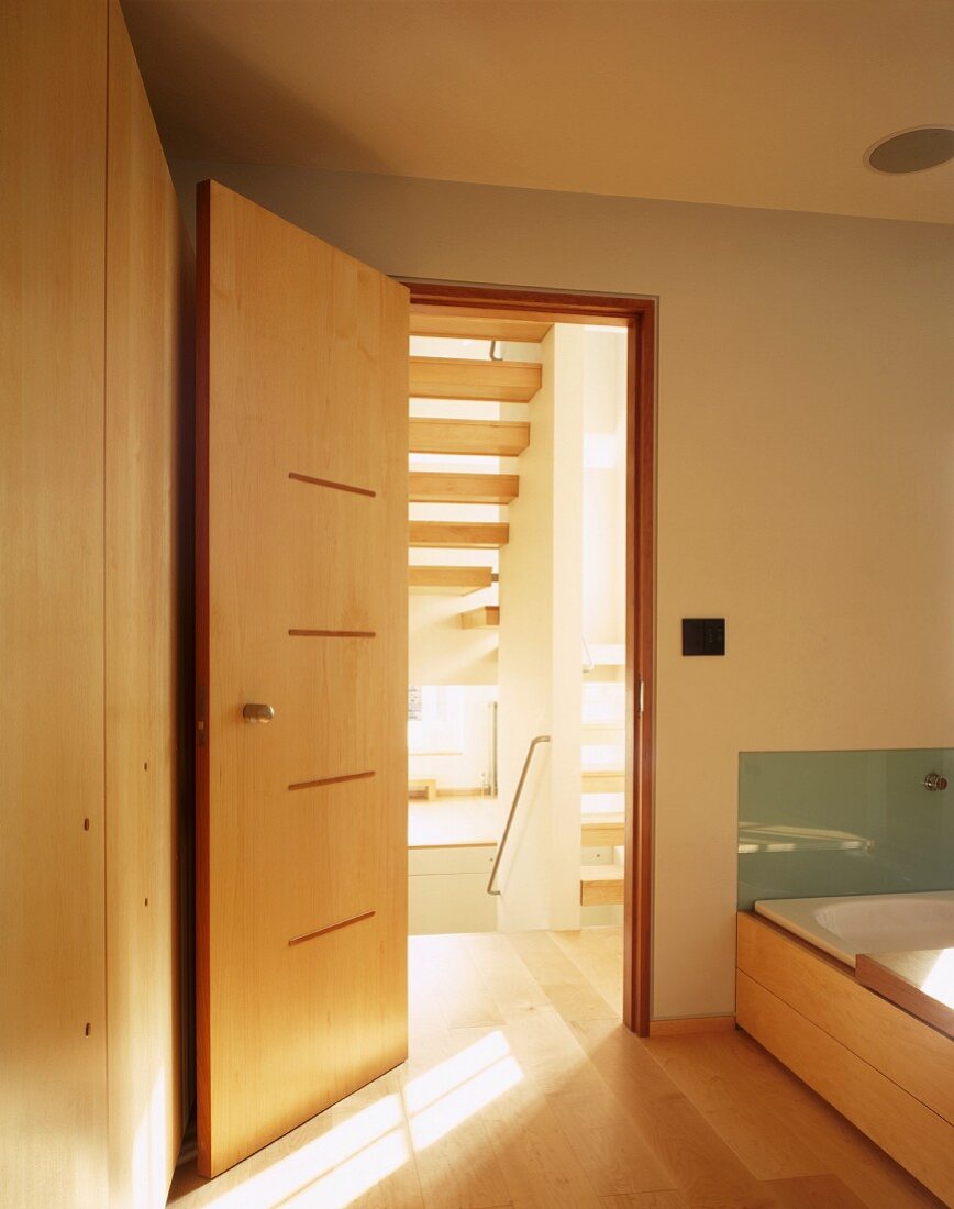 Designerbad mit Badewanne neben offener Holztür im japanischen Stil
