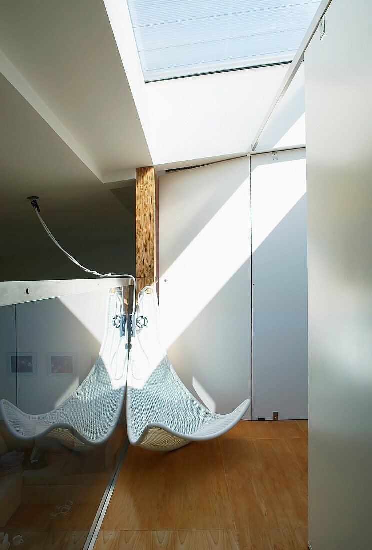 White, rattan, designer lounger in the corner of a room