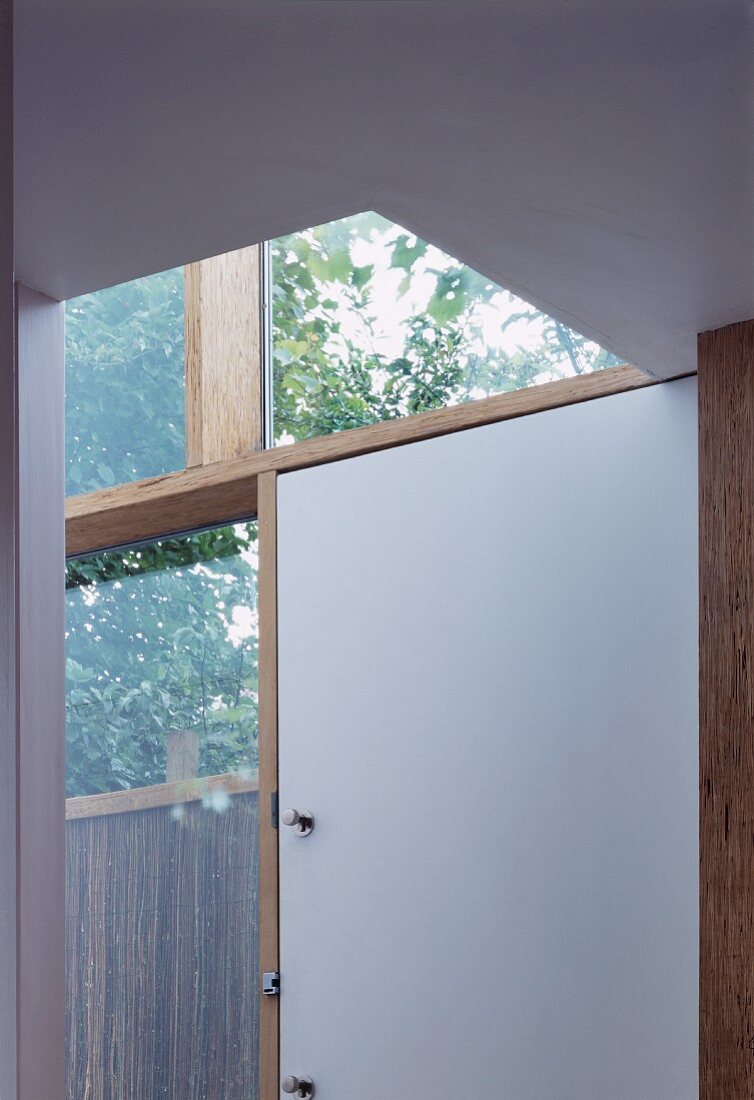 Ausschnitt Hausfassade mit Holzglaskonstruktion und weisser Eingangstür