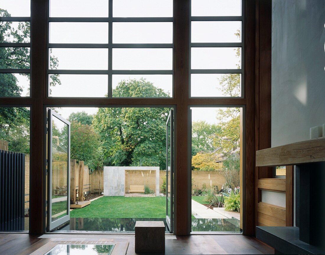 Wohnraum im japanischen Stil mit offenen Terrassentüren und Blick in Garten