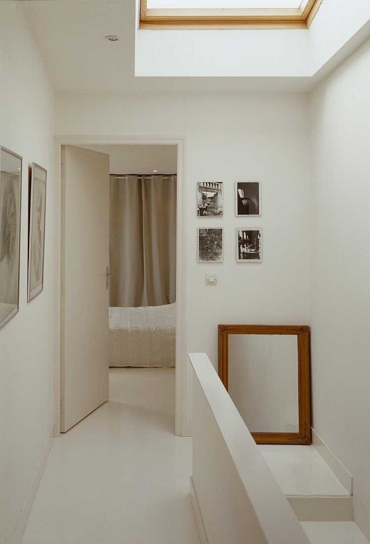 Stairway in a white hallway with open door to the bedroom