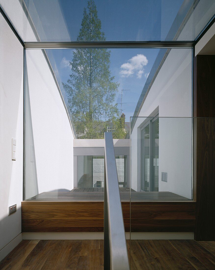 Modern stairway with large bank of windows and glass roof with a view of a courtyard