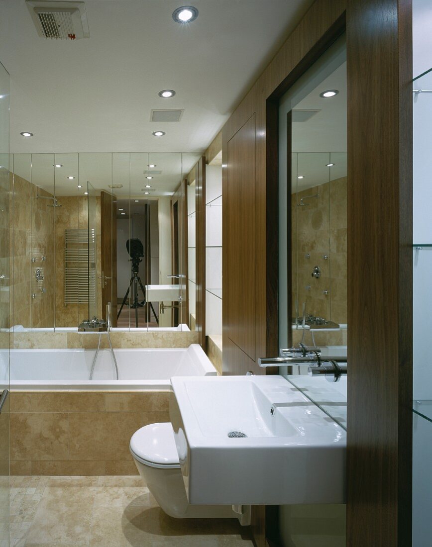 Modern vanity with ceiling high wood frames and bathtub in front of a mirrored wall