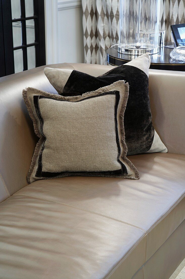 Kissen in Brauntönen auf Sofa mit hellbraunem Lederbezug