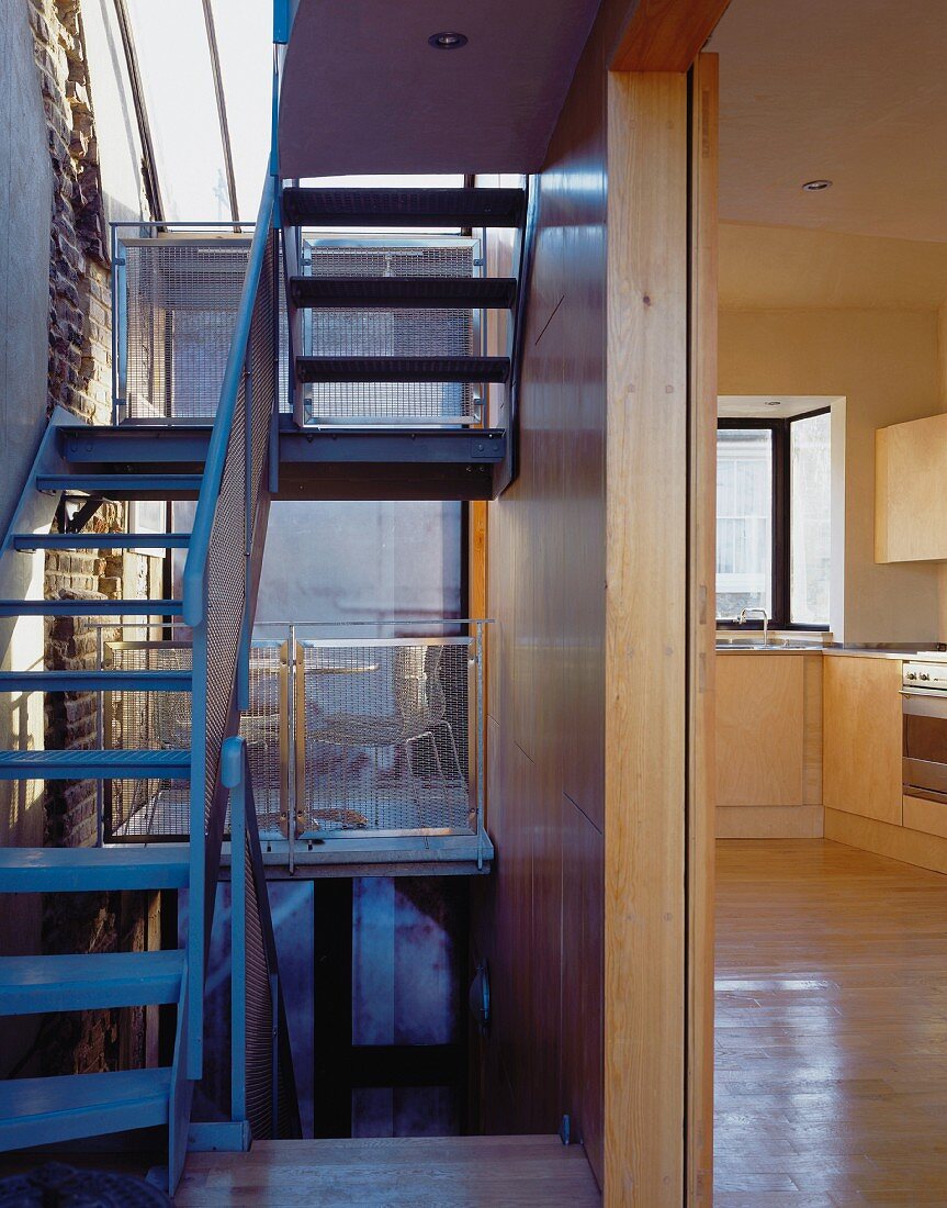 Open staircase and view through a hallway into a kitchen
