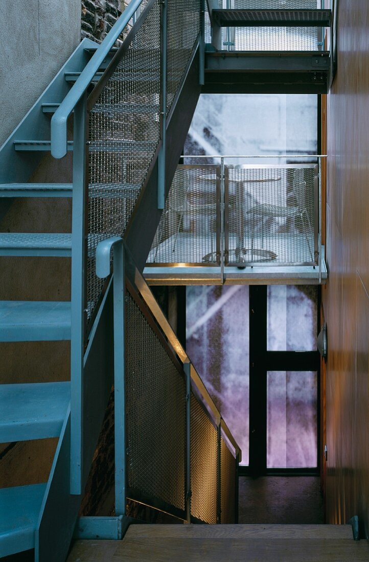 Schmales Treppenhaus mit Metalltreppe und Geländer