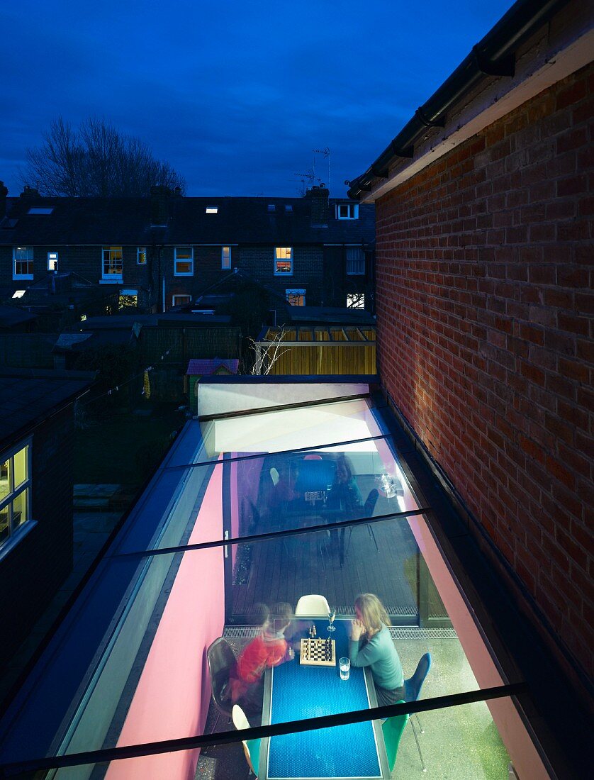 Evening mood - view through a skylight of a dining table with a family playing chess