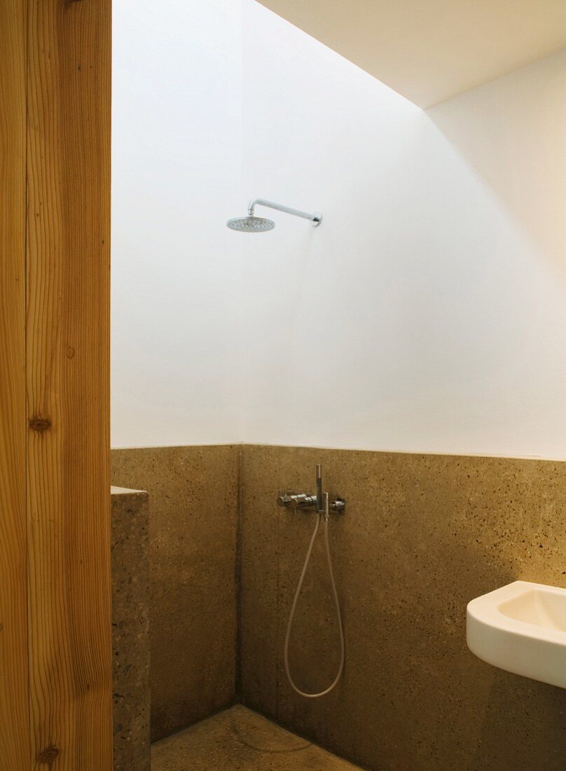 Minimalist shower area with half-height stone cladding