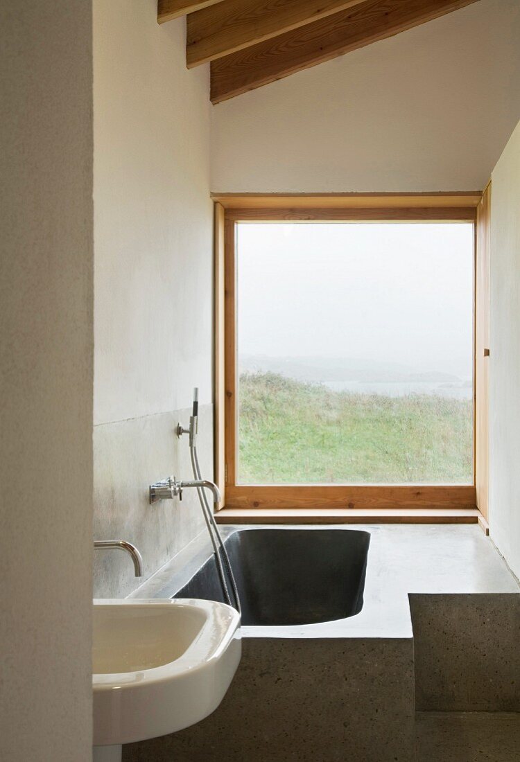 Custom made stone bathtub in a small bathroom with a fantastic view