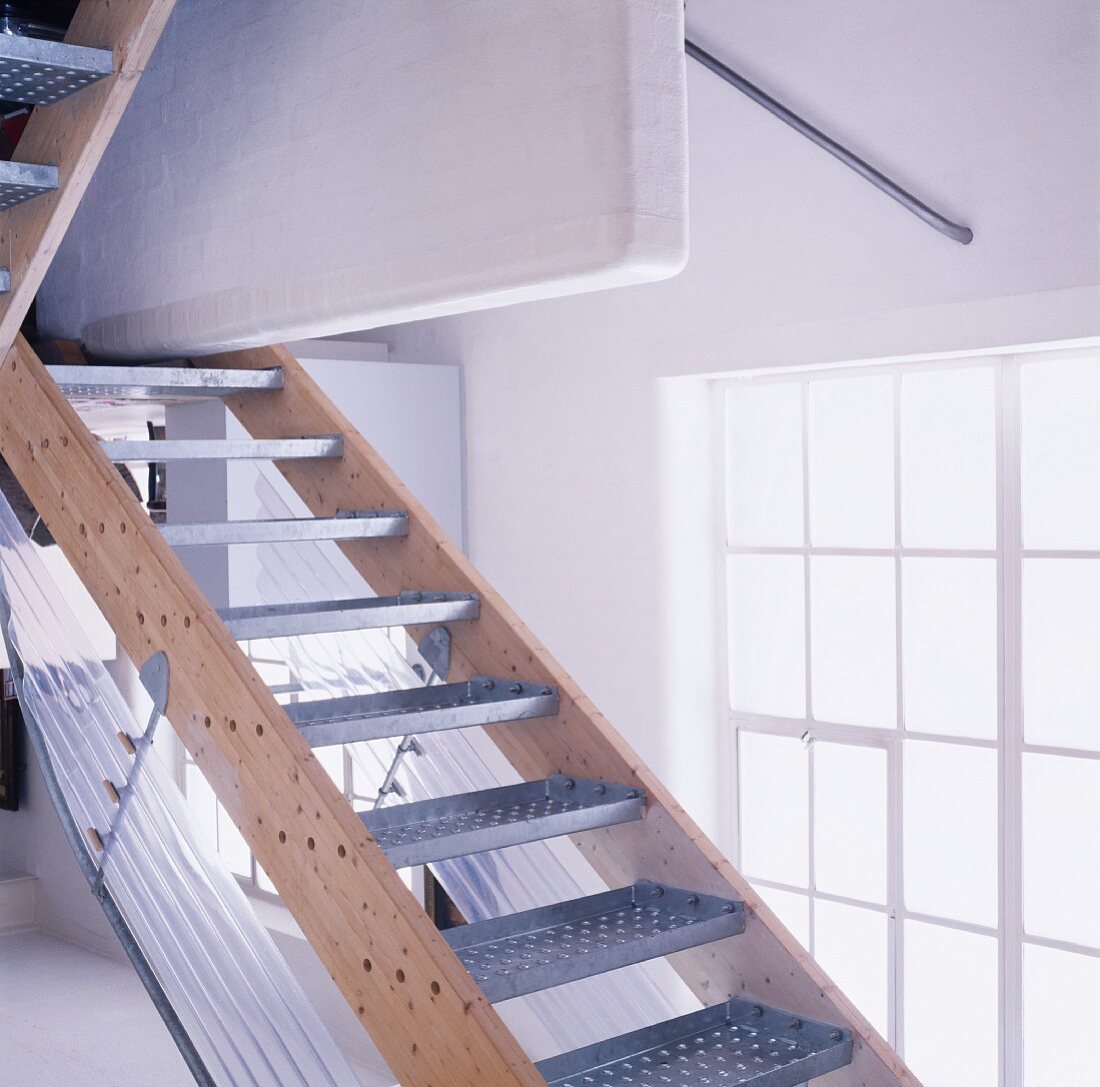 Einfache Treppe mit Metallstufen vor Atelierfenster