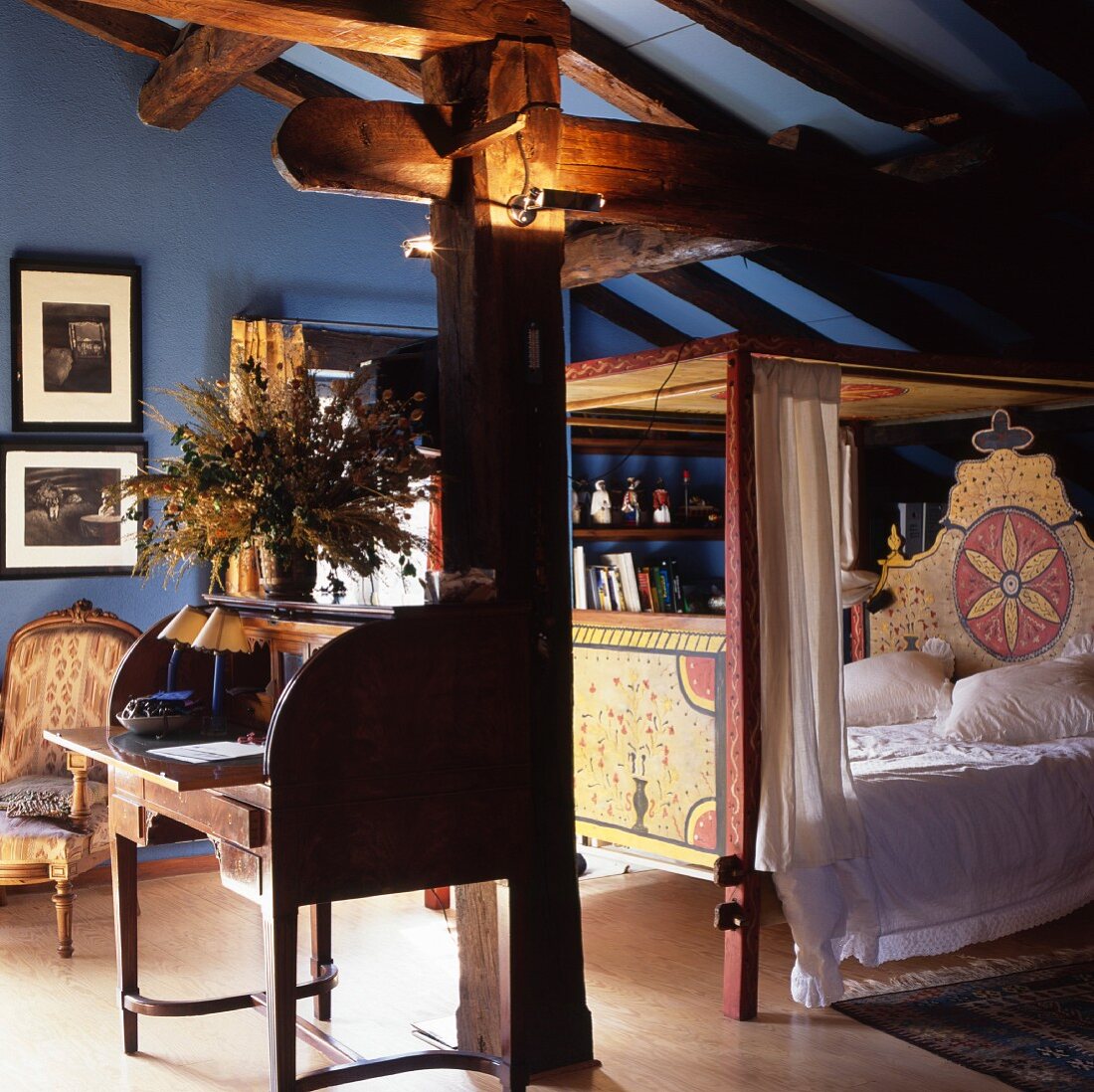 Attic room in shades of blue with painted four poster bed and open secretary