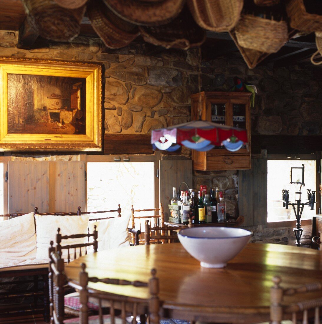 Runder Esstisch aus Holz und Stühle mit geschnitzten Lehnen in spanischer Küche im Rustiko