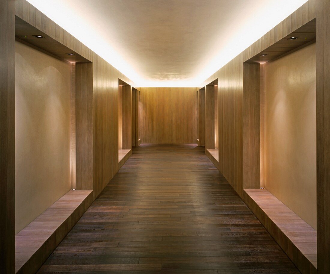 Modern, minimalist lobby with wood built-ins and indirect ceiling lighting