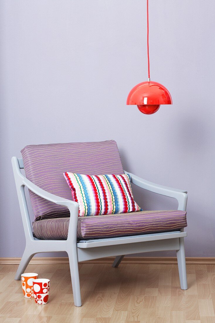 Red hanging lamp above an armchair (50s-60s style)