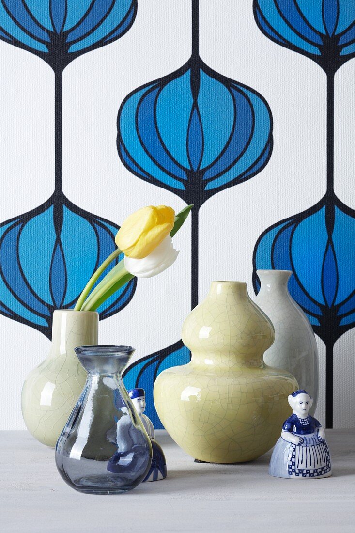 Vasen mit Tulpen vor Vintage-Tapete mit Zwiebelmuster
