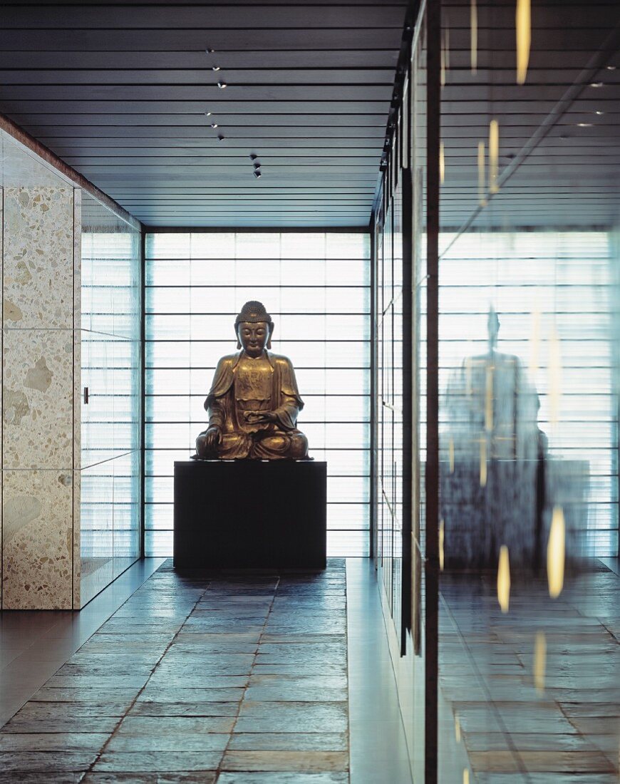 Buddha statue in a minimalist lobby on slate tiles