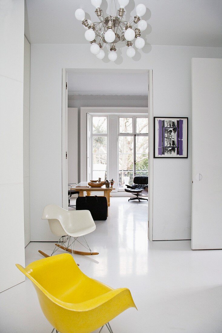 A yellow Bauhaus-style chair in a white, open-plan living room