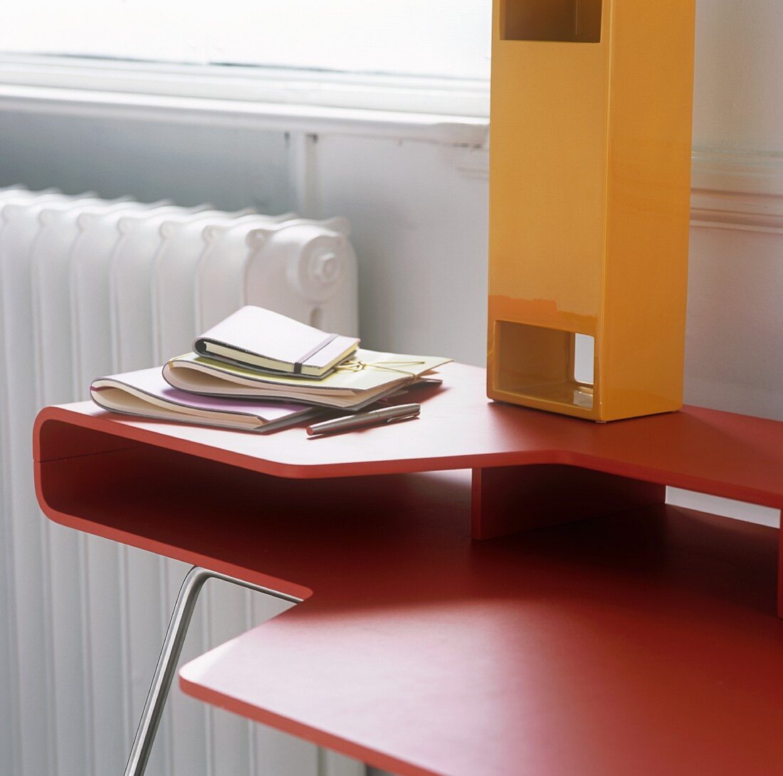 A red, designer desk and a yellow box with an opening