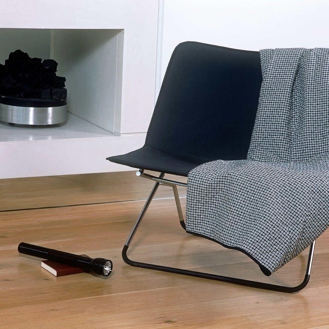 A chair with a stainless steel frame in front of a fireplace