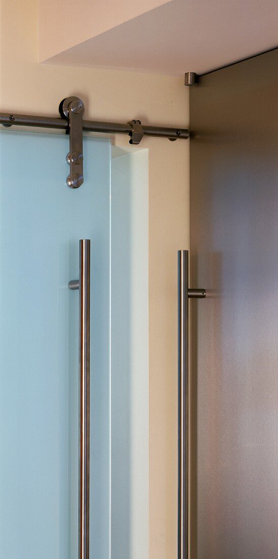 Cupboard handle rail next to stainless steel glass door fitting