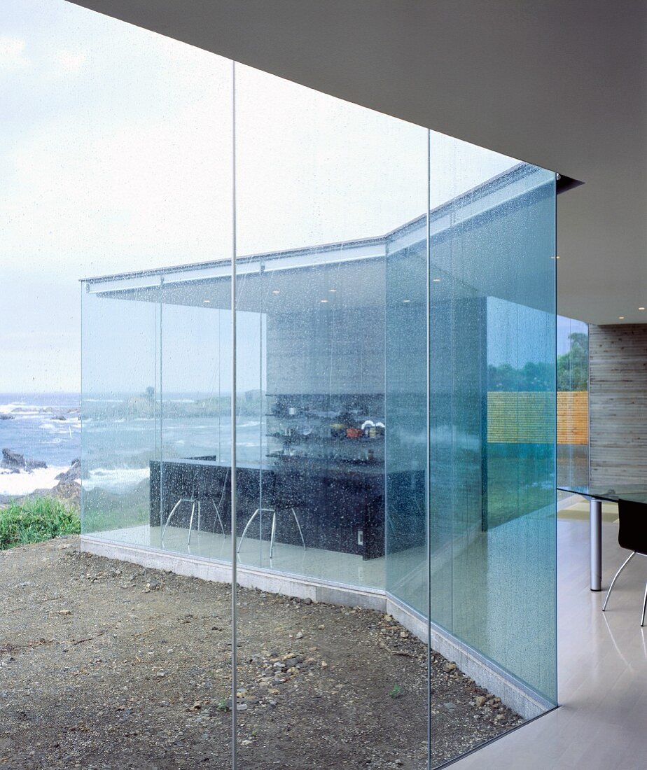 Transparentes zeitgenössisches Wohnhaus mit Glasfassade am Meer