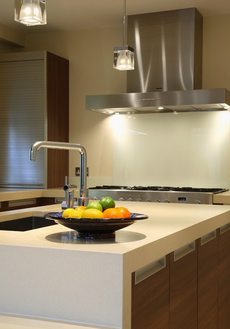 Obstschale auf Küchenblock mit Spülbecken in moderner Einbauküche mit Holzfronten und Edelstahlelementen