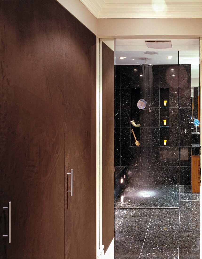 Modernes Bad mit schwarzen, gesprenkelten Fliesen und Spiegeleffekten in Glasabtrennung der bodengleichen Dusche