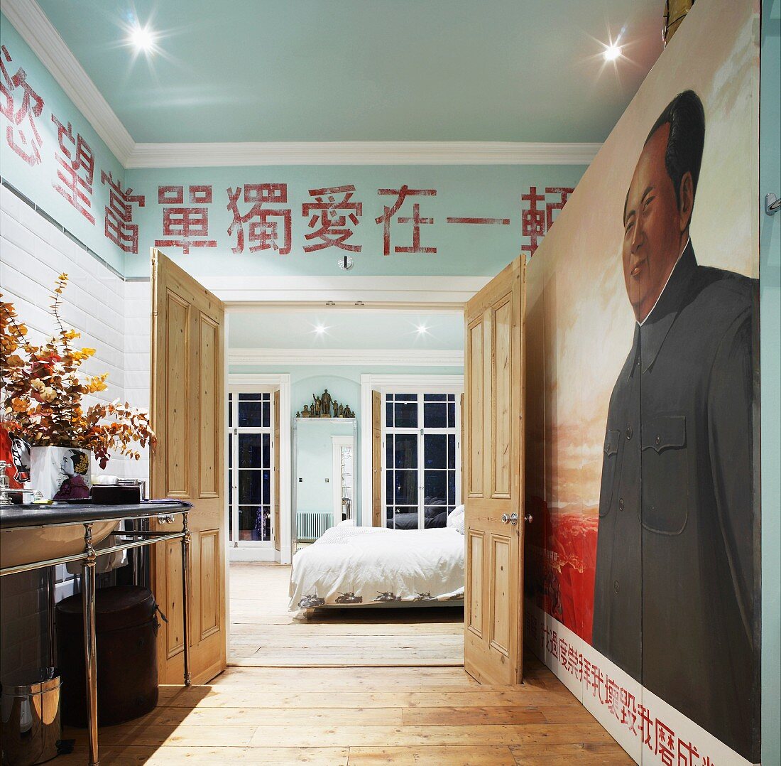 Bad ensuite mit Wandbild und asiatischen Schriftzeichen an Wand über offener Schlafzimmertür