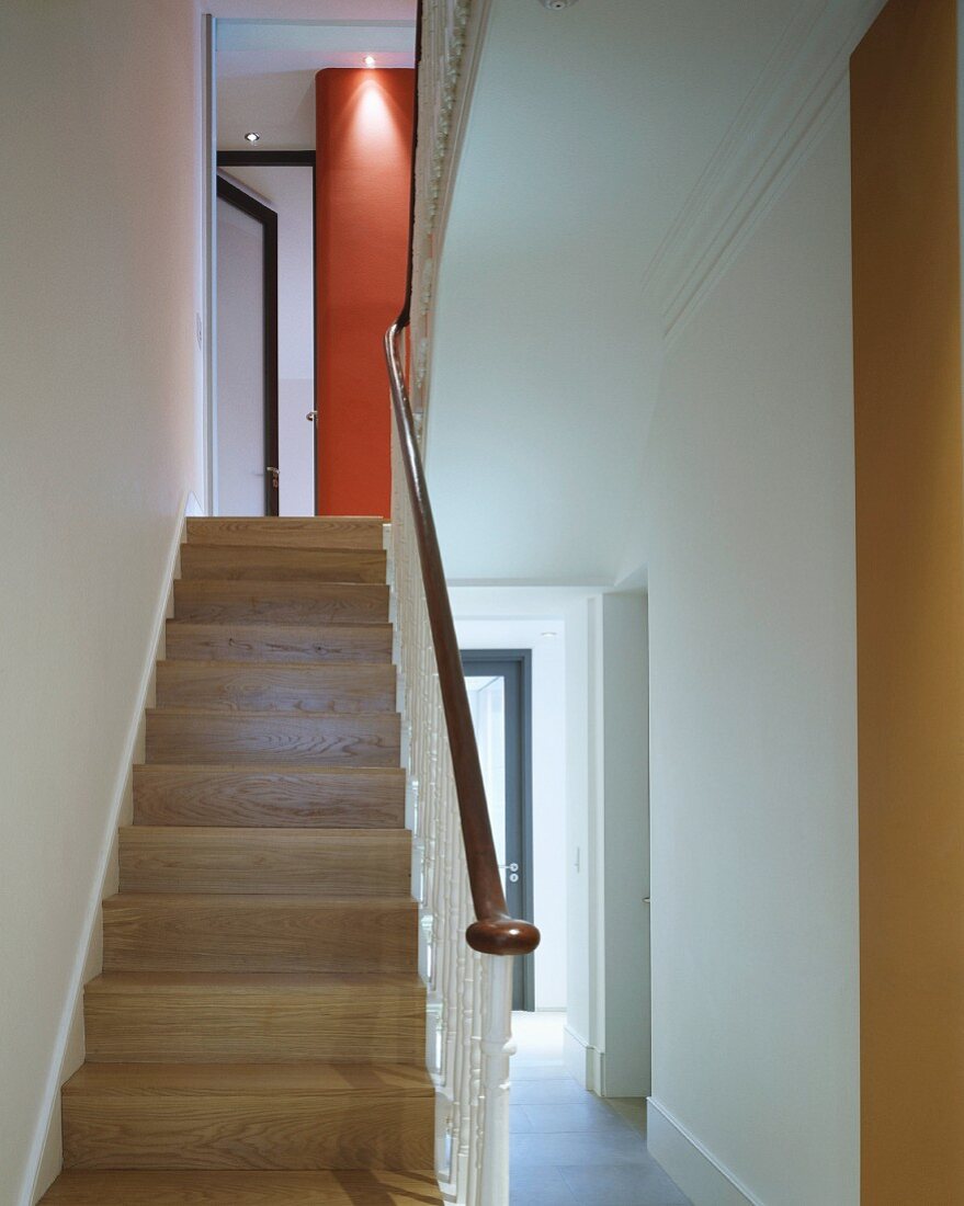 Moderner Eingangsbereich mit Holztreppe und schmiedeeisernem Geländer