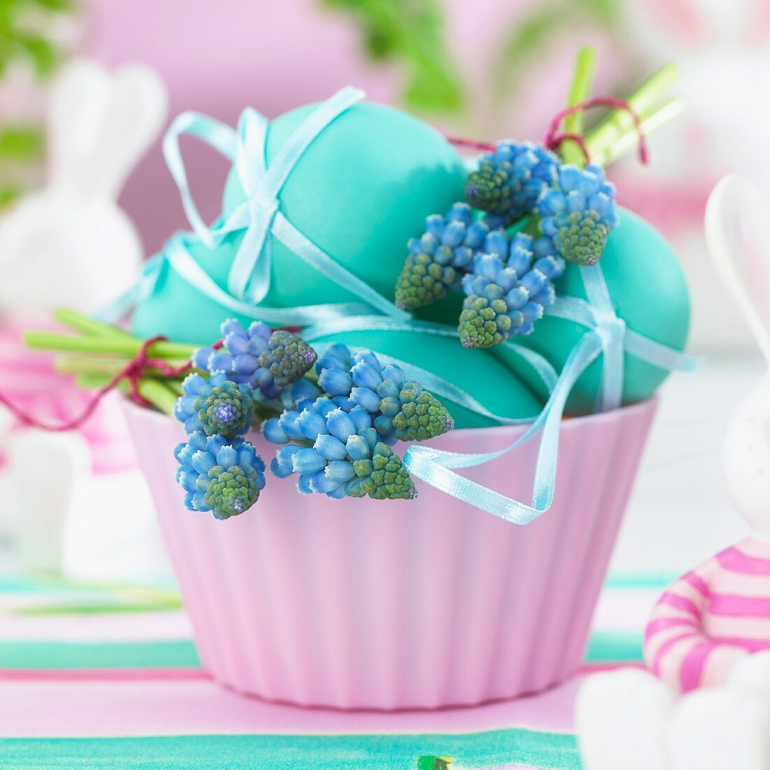 Blue Easter eggs and grape hyacinths in a bowl