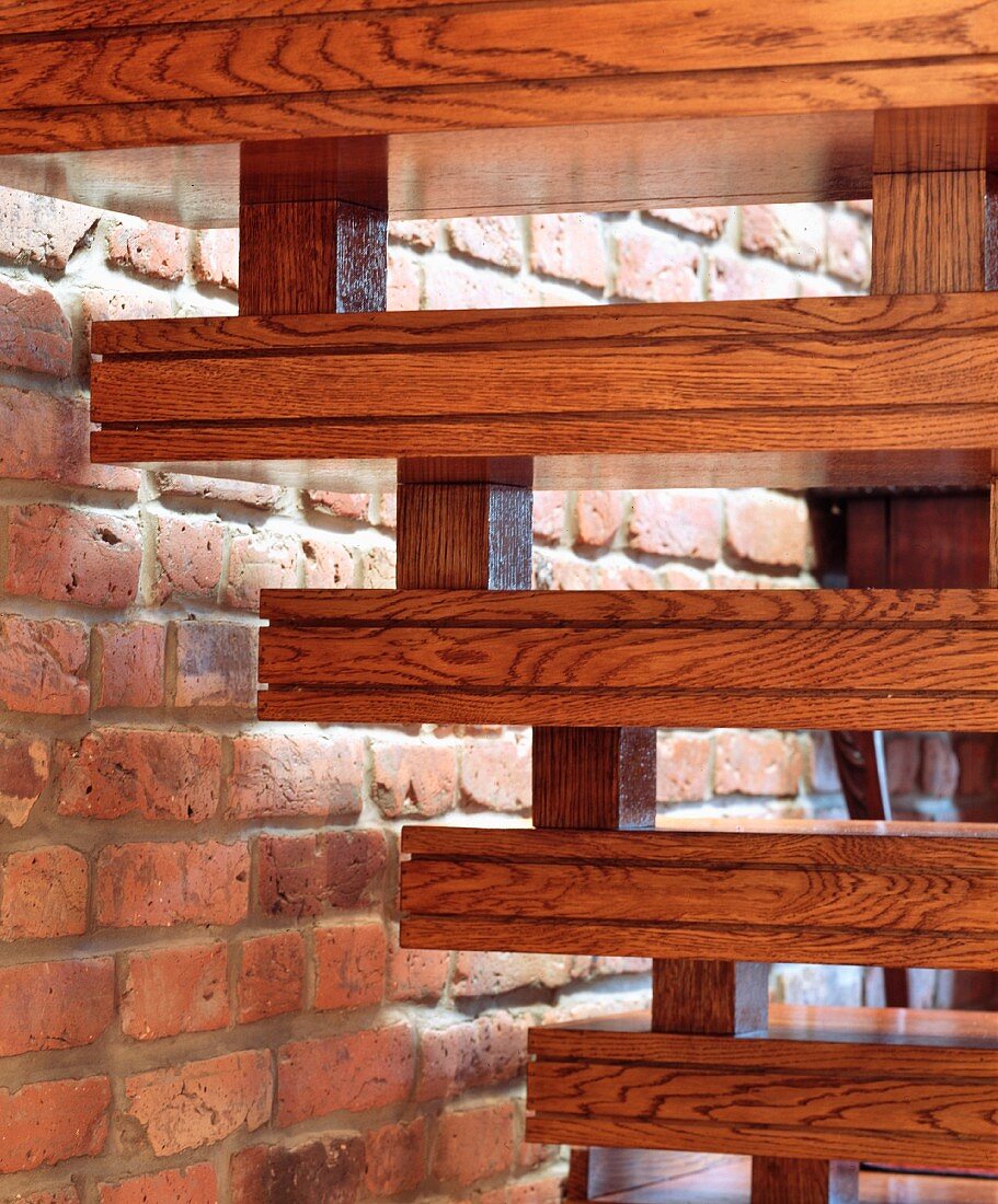 Wooden stairs ornamented with double grooves next to an exposed brick wall in an English house