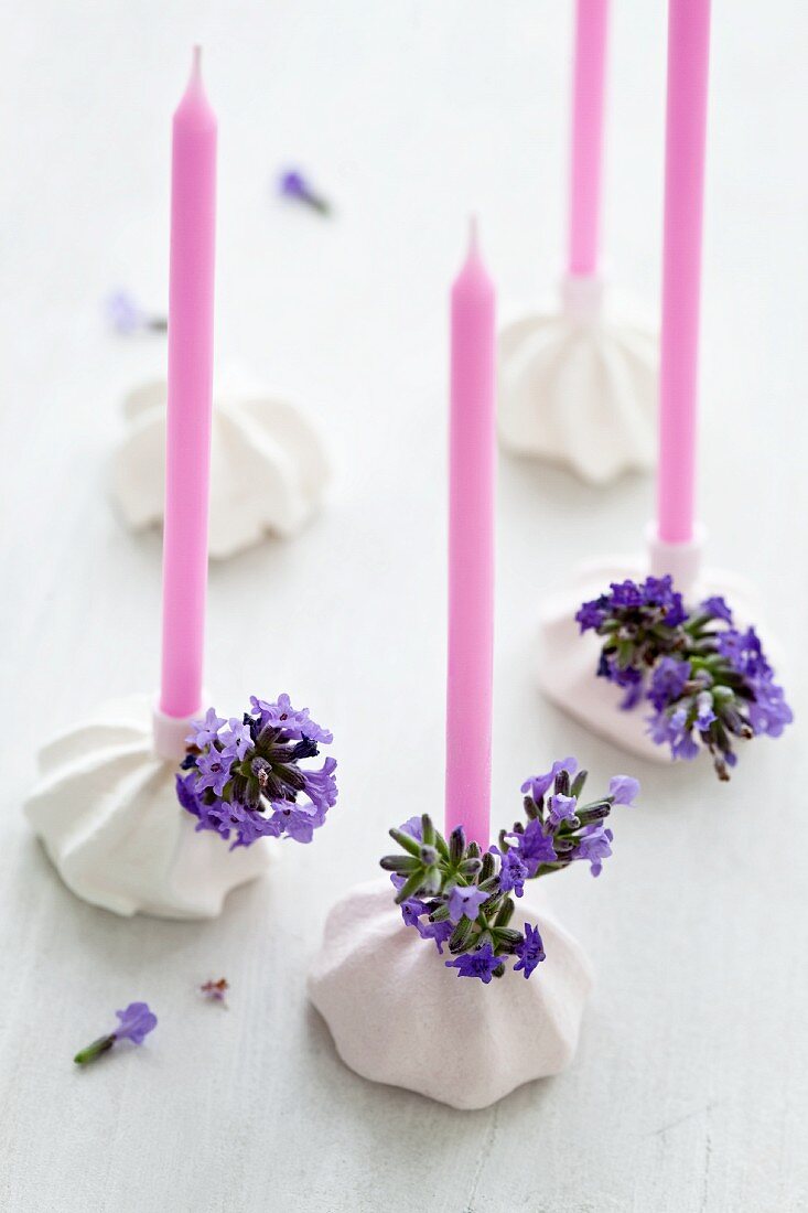 Kerzen in Kerzenständern aus Baiser mit Lavendelblüten verziert