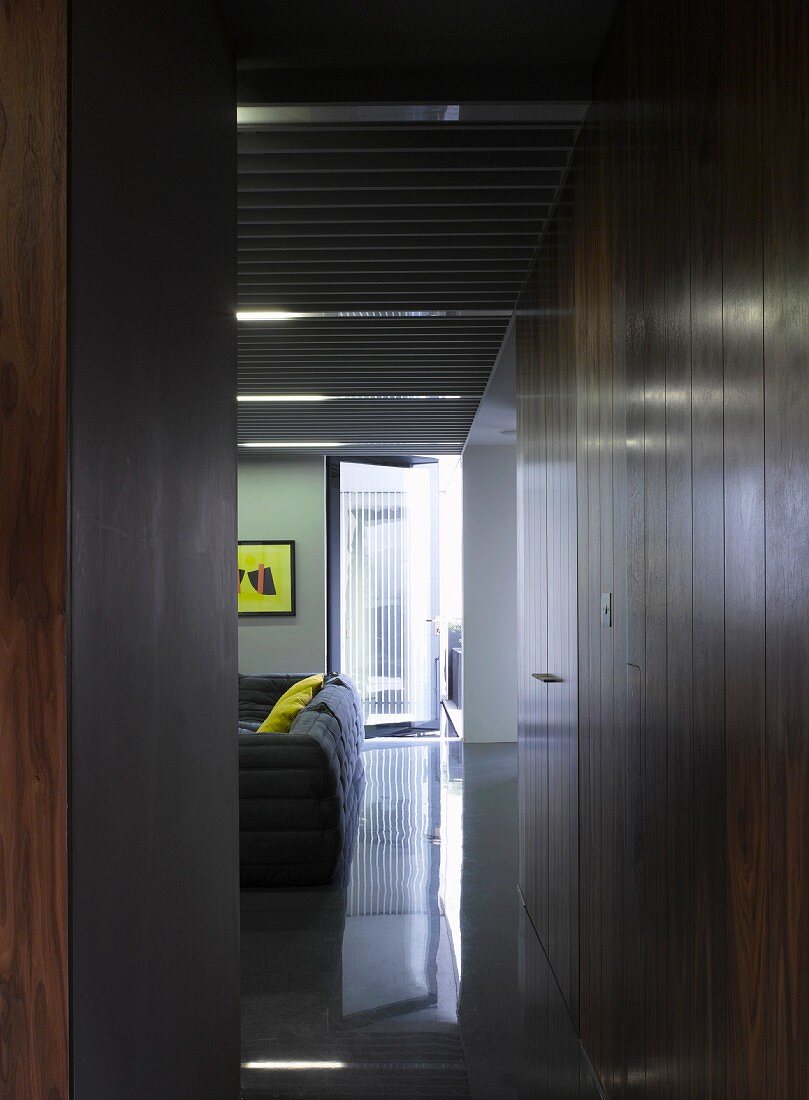 Blick durch schmalen Durchgang auf Einbauschrank aus Holz im modernen Wohnraum
