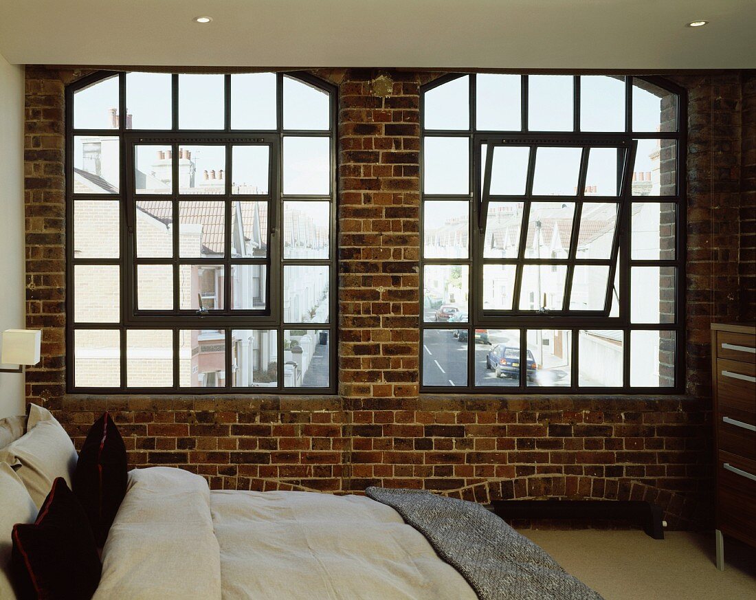 Schlafzimmer mit Sprossenfenster in Ziegelwand