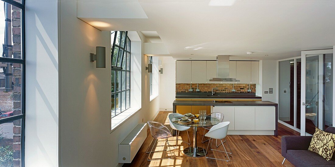 Loftartiger Wohnraum mit modernem Essbereich vor Küchenblock